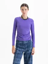 Top de lycra color violeta, con cuello redondo, mangas largas y detalle de frunces laterales en la cintura que aportan movimiento a la prenda.