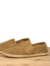 Alpargatas color beige con capellada perforada y suela de yute.