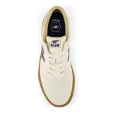 Championes New Balance Numeric 272, color crema con logo lateral en azul marino y suela de goma color caramelo. Confeccionados en una combinación de gamuza y materiales sintéticos, diseñados para ofrecer durabilidad y flexibilidad.