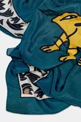 Pañuelo cuadrado de 100x100 cm, con estampado de un tigre amarillo sobre fondo azul y borde con diseño de hojas en blanco y negro.