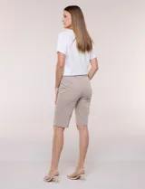 Bermuda elastizada de tiro alto estilo marinero, de silueta ajustada y entallada, con hilera lateral de botones metálicos decorativos.