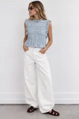 Top celeste y blanco sin mangas con estampa a cuadros vichy, cuello alto con volados y detalles fruncidos en el cuerpo.
