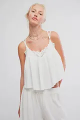 Musculosa blanca de tela liviana con caída amplia, escote en V con aplique de encaje, tirantes finos regulables y diseño corto.