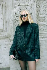 Blazer de corte sastrero y silueta relajada, color negro con estampado floral tono sobre tono. Presenta solapas clásicas, cierre frontal con dos botones y bolsillos laterales con solapa.