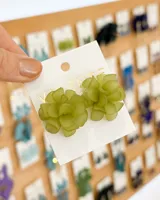 Aros de flores color verde claro con base dorada.