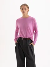 Sweater de tejido de punto en color gris, con cuello redondo, mangas largas y detalle de bordado amarillo en el puño y en el lateral inferior. Presenta un corte recto y estructura ligera.