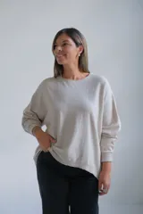 Sweater de punto color beige, de corte holgado y diseño minimalista con cuello redondo y mangas largas.