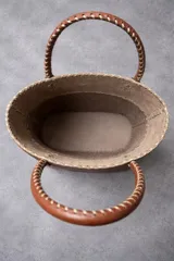 Cartera matera de cuero marrón con diseño bicolor, detalles de costuras visibles y aplique metálico en forma de caballo.