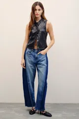 Jean de tiro medio de calce holgado y relajado, con piernas anchas que se estrechan hacia el tobillo. En los laterales, cuenta con recortes a contratono y pinzas que generan una silueta diferencial. Confeccionado en denim azul, presenta charreteras y doble botón en la cintura.