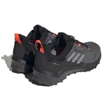 Championes de senderismo Adidas Terrex AX4 GORE-TEX, color gris con detalles en negro y naranja. Cuentan con membrana impermeable GORE-TEX y suela de caucho Continental.