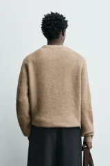 Sweater de punto color beige, de corte relajado, con cuello redondo y diseño texturizado en estructura waffle.