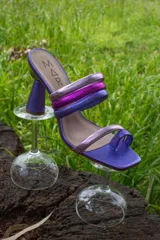 Sandalias de cuero color violeta con tiras finas cruzadas en el empeine en tonos plateado, fucsia y violeta. Taco geométrico de 8,5 cm.