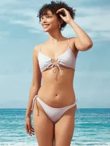 Conjunto de bikini color lila, compuesto por un top con frunces y tiras ajustables en el centro y una bombacha clásica con tiras laterales para anudar.