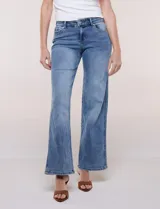 Jean wide leg de tiro medio, color azul claro, confeccionado en denim de algodón con un toque de elastano. Cuenta con cinco bolsillos, presillas para cinturón y cierre frontal con botón. El diseño destaca por su pretina regulable con cruce y broches metálicos.