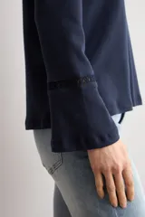 Remera de manga larga color azul marino, con cuello redondo y detalle de puntilla en los puños.