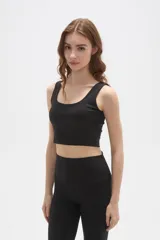Top deportivo de bretel ancho, color negro, con cuello redondo profundo y diseño ajustado al cuerpo.
