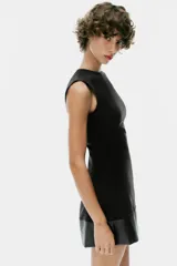 Vestido mini negro sin mangas, de cuello redondo, con detalle de tejido efecto piel combinado a tono en el bajo. Cuenta con forro interior y cierre en la espalda con cremallera oculta.