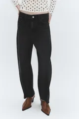 Jeans de tiro medio con corte cropped y diseño de costuras torcidas. Presenta trabillas en la cintura, cinco bolsillos clásicos y cierre frontal con cremallera y botón metálico.