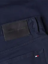 Pantalón de vestir azul marino, de corte recto, con bolsillos laterales y traseros. Se ajusta a la cintura con cinturón de cuero marrón.
