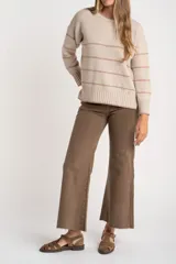 Sweater de punto oversize en color beige melange con diseño de líneas horizontales tostadas, cuello redondo y terminaciones en rib.