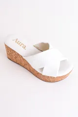 Sandalia color beige con plataforma de corcho y tiras cruzadas de cuero.