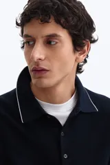 Remera polo azul marino en punto texturizado de mezcla de algodón, con cuello y bordes de mangas acanalados con ribete blanco, tapeta con tres botones y manga corta.