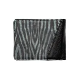 Billetera Volcom tipo bifold, confeccionada en cuero sintético, con diseño combinado en color negro texturizado y estampado animal print en tonos gris y negro. Incluye placa metálica con logo de la marca en el frente.