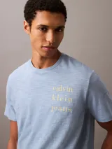 Remera celeste de manga corta con logo de Calvin Klein Jeans estampado en amarillo.