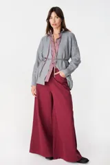 Jean de corte wide leg en color bordó, confeccionado en denim de algodón. Presenta tiro medio, bolsillos traseros amplios y una silueta holgada y fluida.