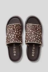 Sandalias plataforma Altin de diseño slip-on, con base marrón de gran altura y capellada en cuero con estampado animal print tipo ciervo en tonos marrones y blancos.