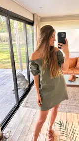 Vestido corto de lino en color verde oliva, con escote estilo bardot (hombros descubiertos) y mangas cortas abullonadas con elástico.