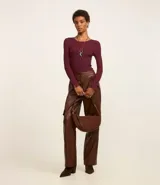 Suéter de punto acanalado color beige, con cuello redondo y mangas largas. Confeccionado en tejido tricot con textura suave y ajuste al cuerpo.