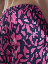 Short de baño con estampado botánico en tonos naranja y coral, con cintura elástica ajustable mediante cordón y malla interior para mayor soporte.