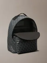 Mochila Calvin Klein con estampado integral de monograma CK en tonos oscuros. Cuenta con un compartimento principal amplio, bolsillo frontal con cierre, asa superior y compartimento interno para laptop.