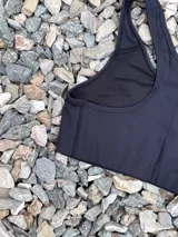 Top deportivo negro con espalda tipo nadadora y breteles anchos.