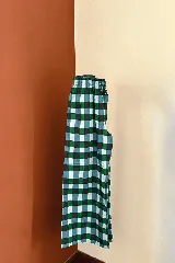 Pantalón de corte holgado y tiro medio, con estampado de cuadros grandes en tonos bordó y violeta. Cuenta con cintura elástica con cordón ajustable y bolsillos laterales.