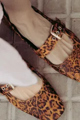 Chatitas tipo Mary Jane de charol negro con punta redondeada y tira sobre el empeine con hebilla metálica plateada.