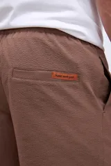 Short de baño color verde oliva, con cintura elástica y cordón ajustable en color crudo.