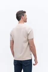 Remera de algodón con cuello redondo, manga corta y calce regular. Presenta un diseño minimalista con una pequeña estampa circular centrada en el pecho.