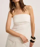 Blusa strapless de sastrería color blanco marfil con sutiles rayas verticales, escote recto doblado y diseño entallado.