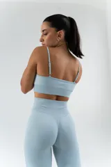 Conjunto deportivo celeste compuesto por un top con tirantes finos y calza larga de cintura alta.