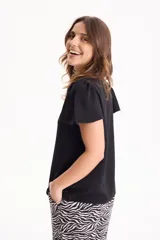 Blusa de manga corta con pliegues en escote redondo, confeccionada en tela crepé de color beige.