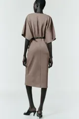 Vestido midi de escote en pico cruzado y manga corta. Presenta detalle de frunces en la cintura y un cinturón integrado con hebilla metálica a contraste.