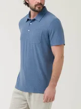 Remera tipo polo de manga corta en color azul jaspeado, con cuello clásico, cierre frontal de dos botones y un bolsillo aplicado en el pecho.