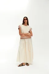 Top tejido de punto color crudo, con cuello redondo y mangas cortas con terminaciones acanaladas a rayas de colores.