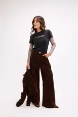 Remera de diseño superpuesto que combina una remera de manga corta en color negro con estampa frontal y mangas largas en color gris topo. Presenta un estilo urbano y moderno con corte holgado.