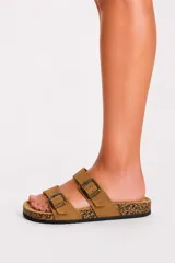 Sandalia plana de color tostado con diseño de tiras cruzadas y doble tira superior con hebillas metálicas ajustables, plantilla estilo corcho y suela negra.