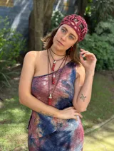 Collar de estilo artesanal con dije de coral natural en tono rojo intenso, engarzado en metal plateado. Cuenta con un cordón sintético color camel ajustable que permite variar el largo y usarlo de diferentes formas.