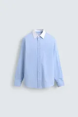 Camisa de corte regular fit confeccionada en algodón, con estampado de rayas verticales en tonos azul y blanco. Presenta cuello italiano en color blanco a contraste, cierre frontal de botones y mangas largas con puños dobles.