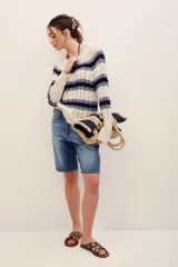 Sweater de punto con rayas horizontales en tonos beige y azul marino, manga larga y cuello redondo.